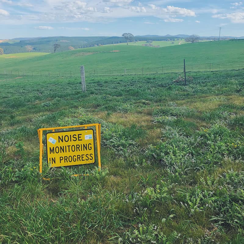field with noise monitoring in progress sign