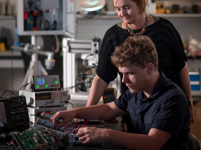 Male apprentice is supervised by female technician