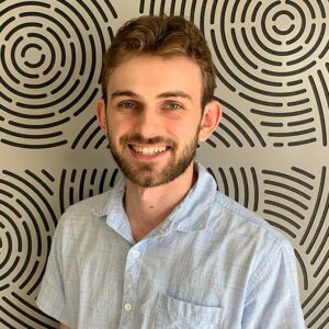 Headshot of Lachlan in front of patterned background 